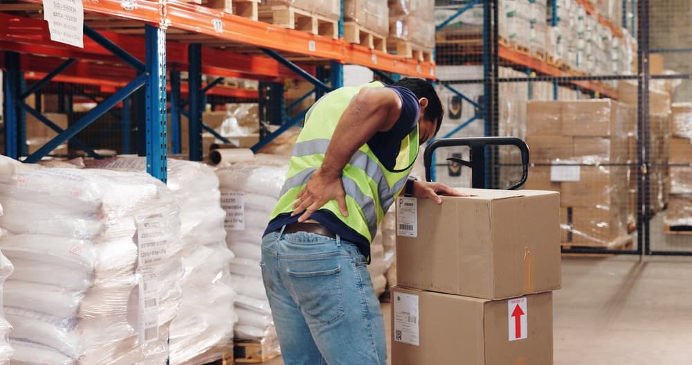 Pallet truck, man and back pain in warehouse with transport, safety and storage for distribution or delivery.