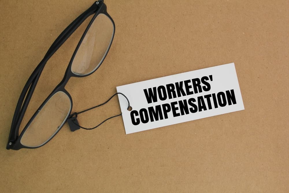 Glasses and a paper tag with the word workers' compensation