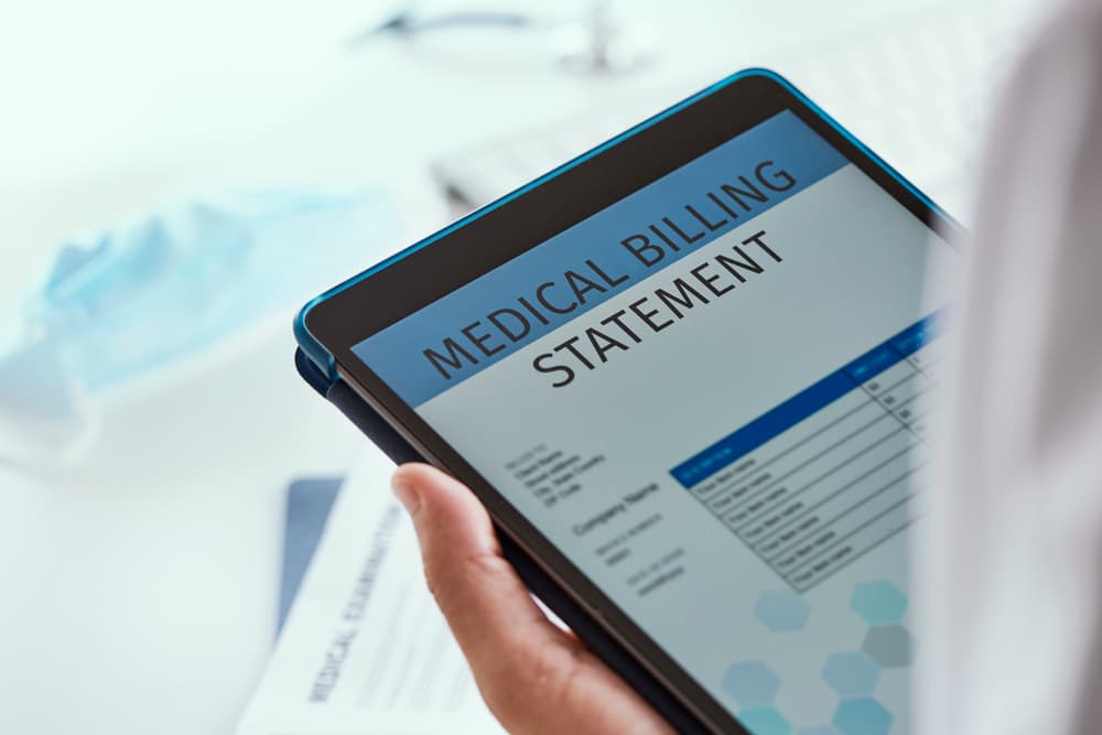 A doctor checking a medical billing statement in a digital tablet.