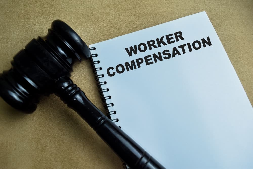 Worker Compensation write on book isolated on Wooden Table.