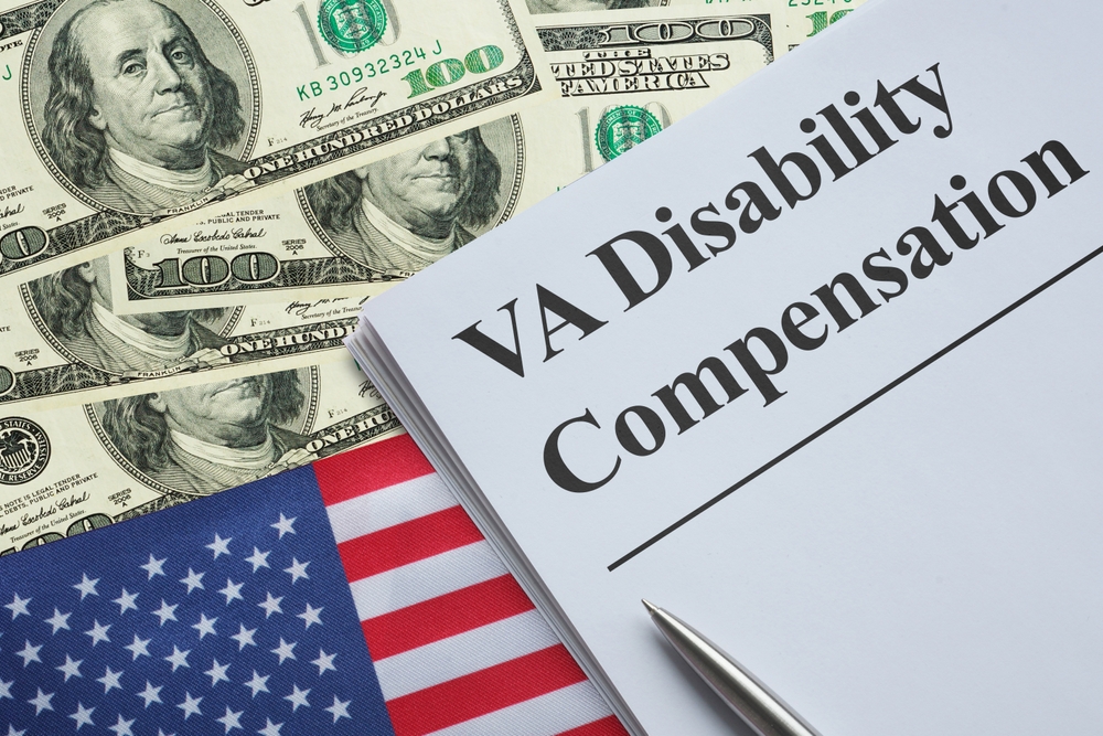 VA disability compensation paperwork with U.S. flag and hundred-dollar bills